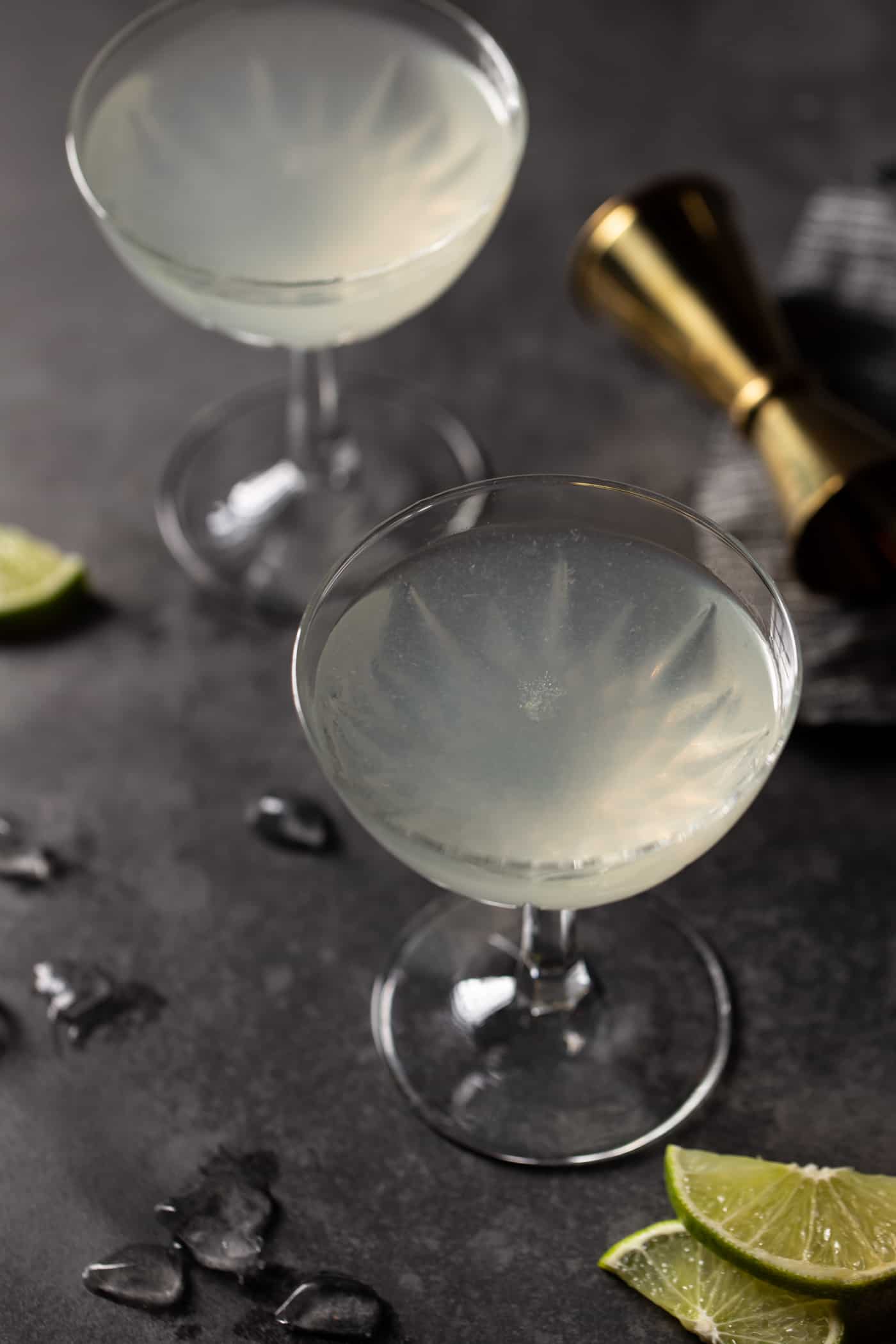 Top down view of two coupe glasses filled with Elderflower Gin Gimlet Cocktails. 