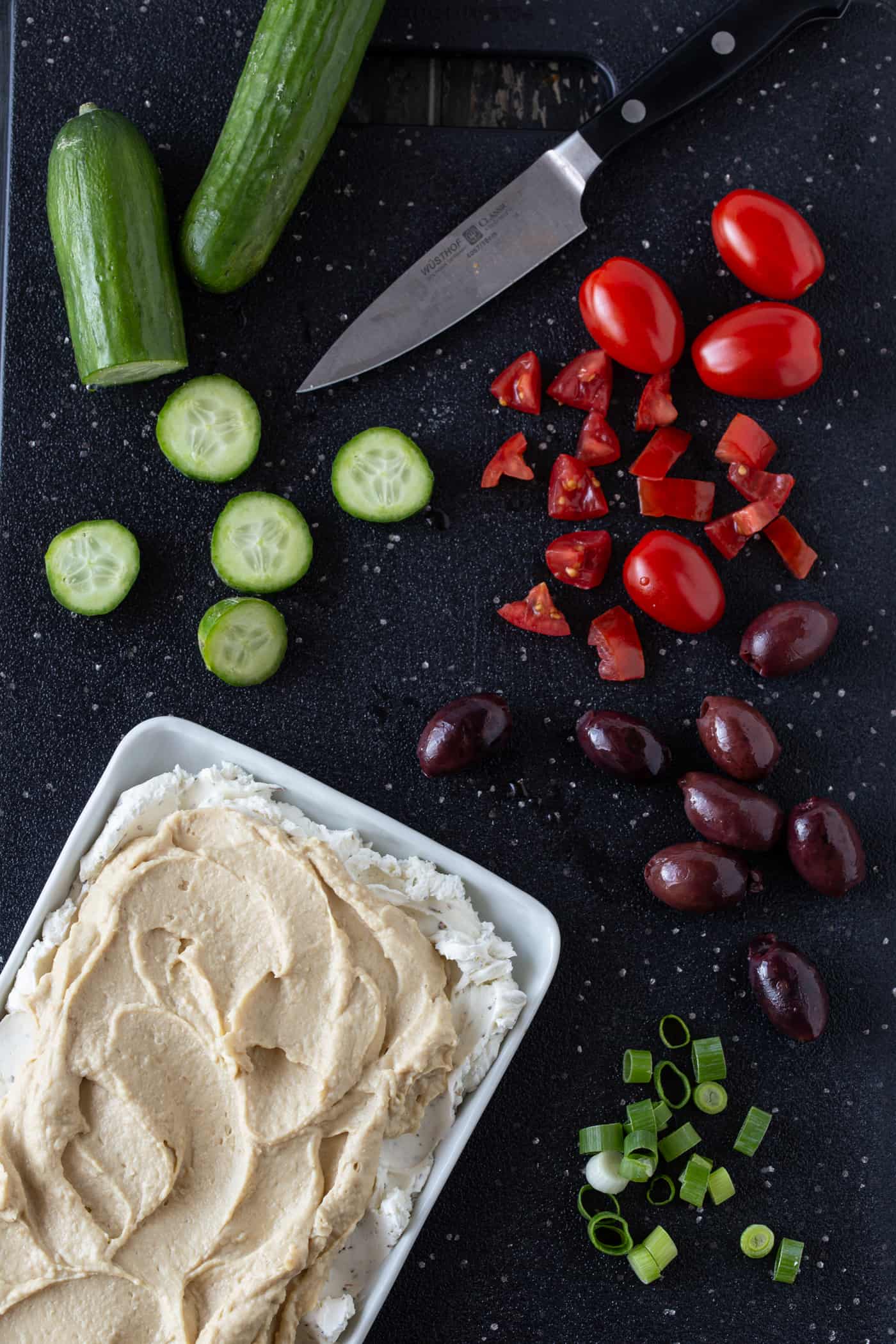 Greek Dip ingredients including olives, cucumbers and tomatoes.