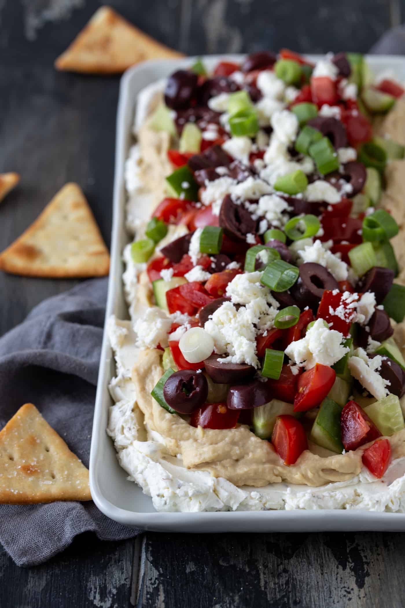 Greek Dip on a white platter surrounded by pita chips.