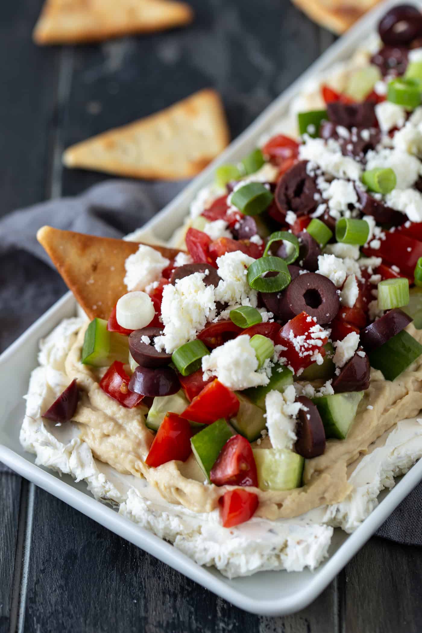 White platter filled with Greek Dip and pita chips. 