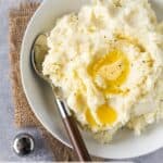 mashed potatoes in white bowl with spoon.