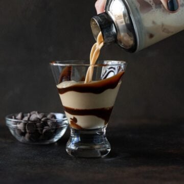 martini being poured into chocolate swirled glass.