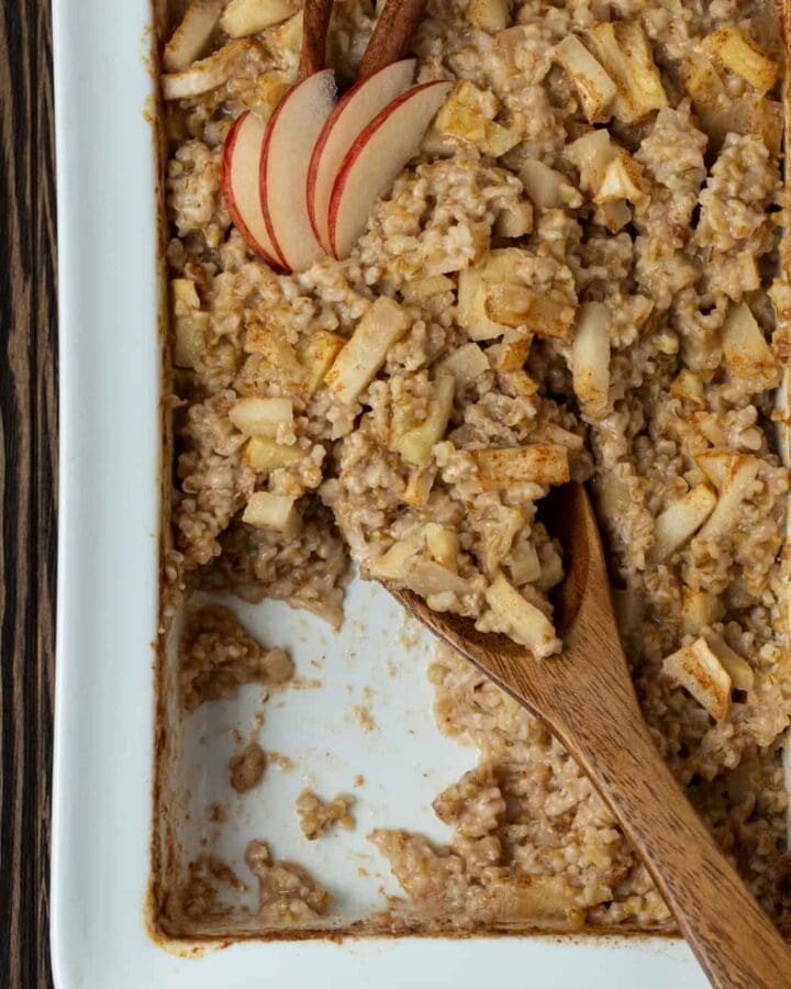 A dish is filled with oatmeal , with Apples and cinnamon.