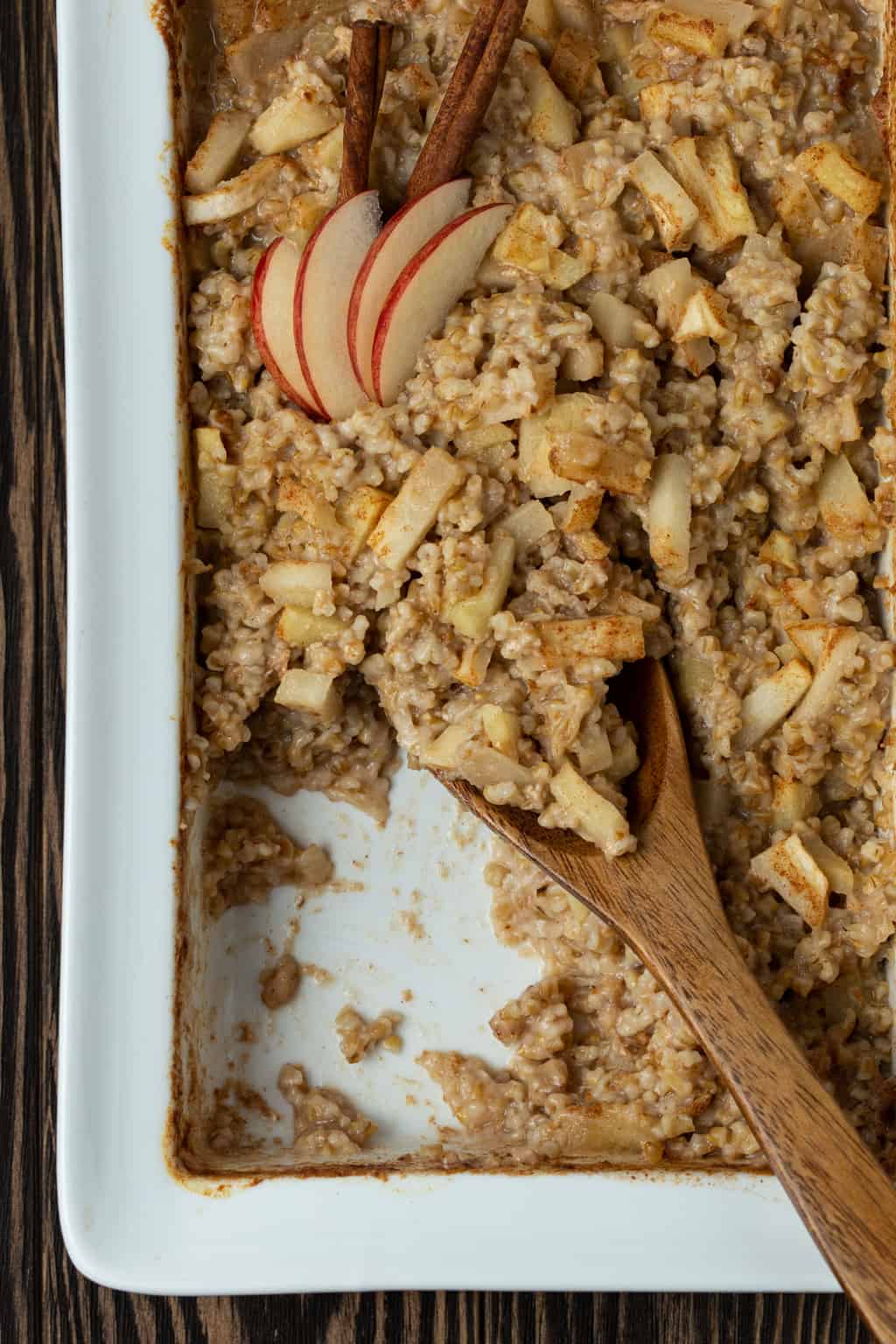 A dish is filled with oatmeal , with Apples and cinnamon.