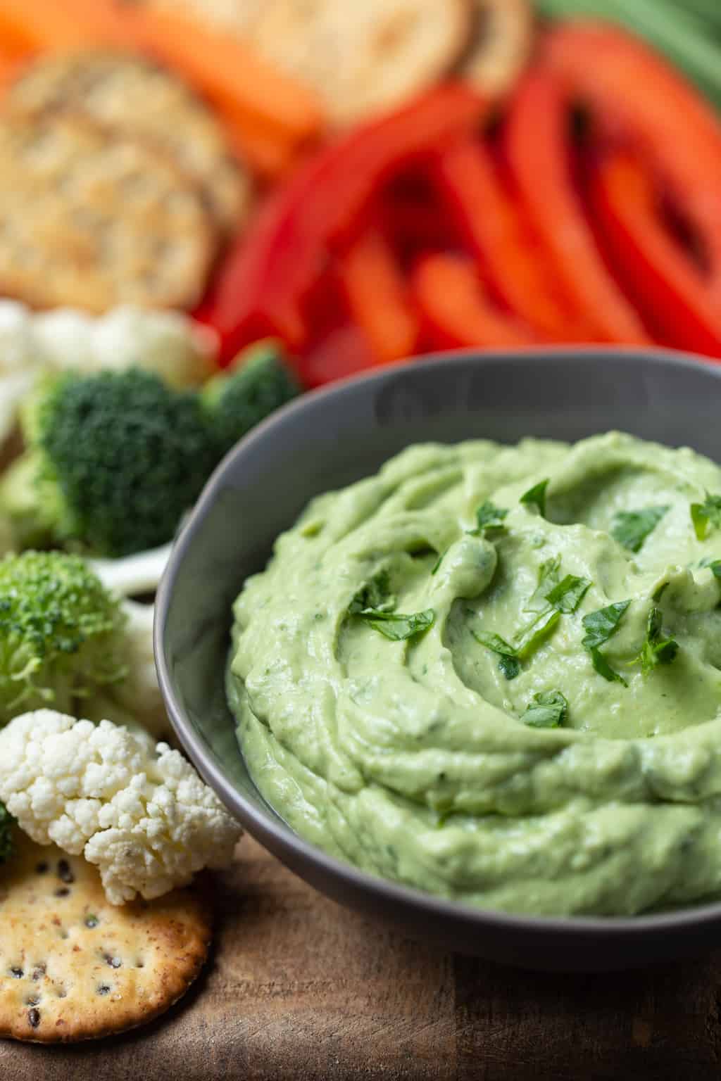 A plate of food with broccoli, cauliflower and peppers, with Avocado Yogurt dip.