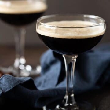 coupe glass filled with coffee drink with espresso beans.