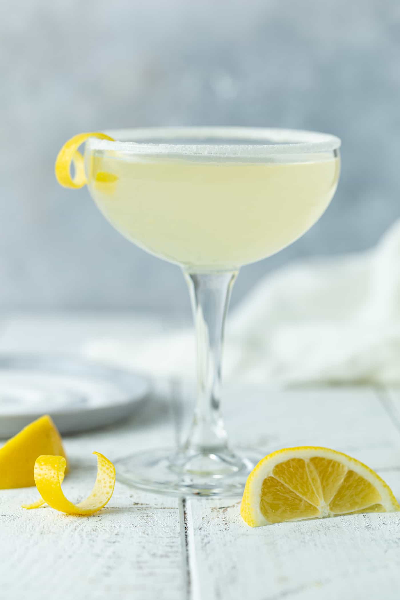 A small coupe glass, with Lemon and Martini.