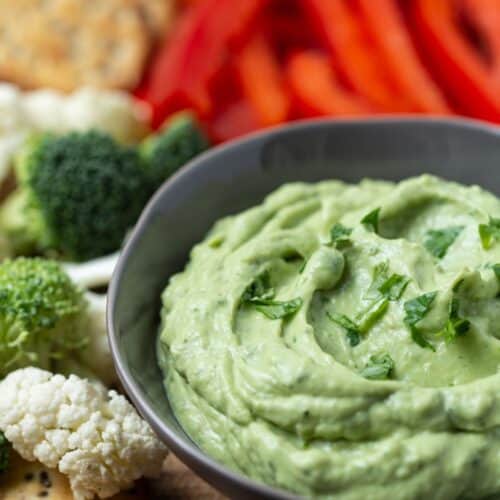avocado dip in bowl with fresh veggies.