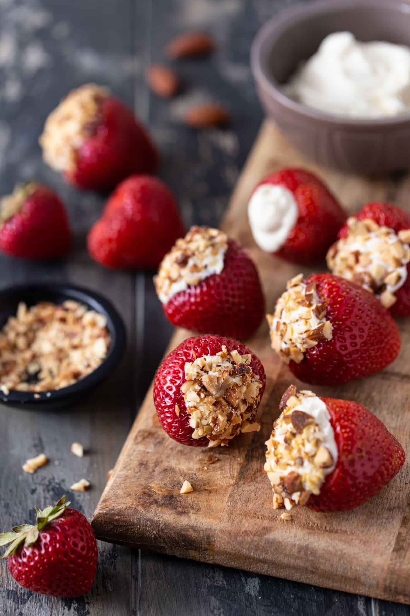 Cheesecake Stuffed Strawberries on a wood cutting board