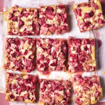 rhubarb bars cut on parchment paper.