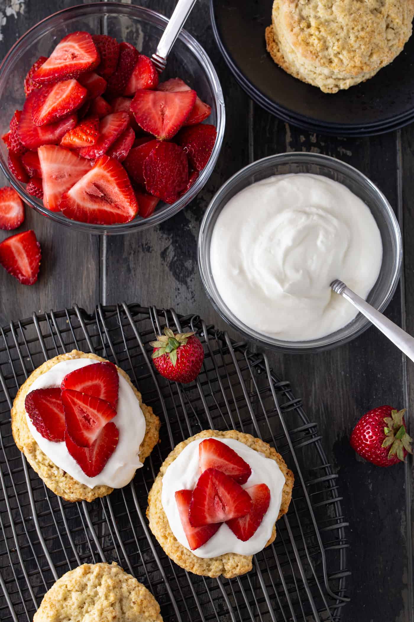 Strawberries, whipped cream and biscuits topped with fruit.