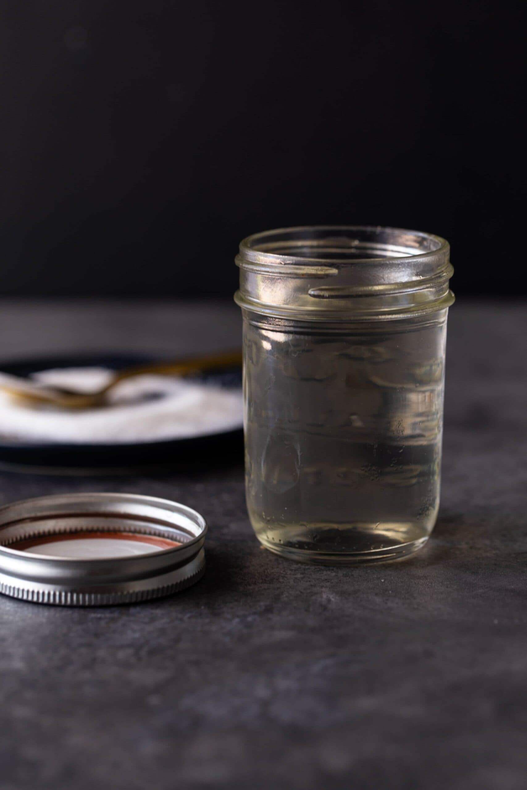 A glass cup on a table, with Simple Syrup.