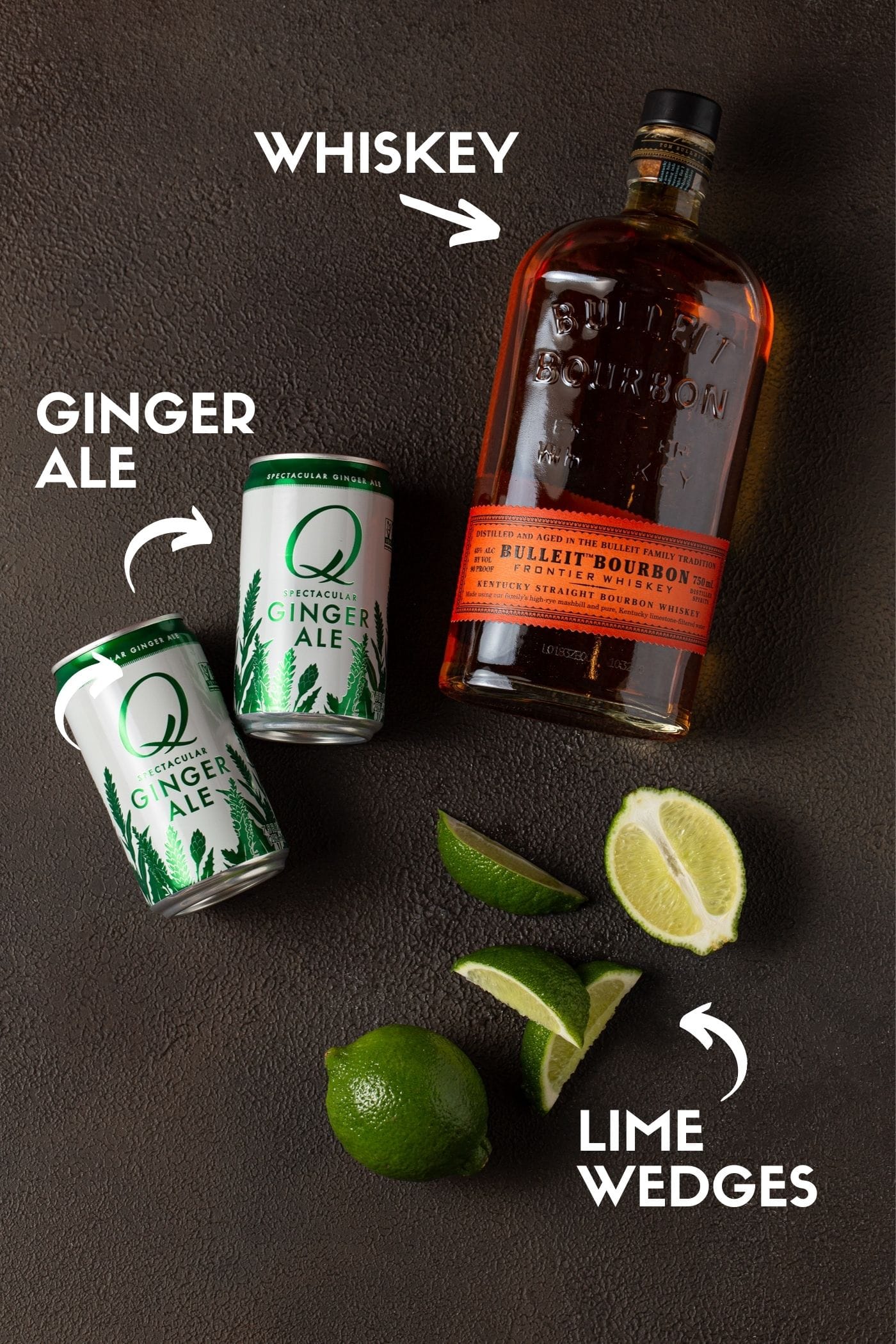 Ingredients for Whiskey Ginger drink, including, whiskey, ginger ale and lime wedges.