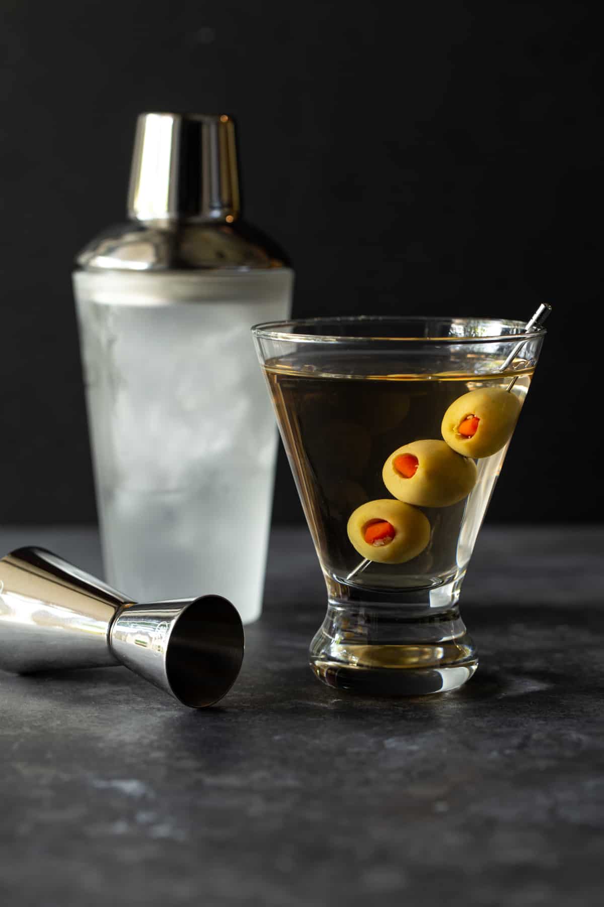 A close up of a glass cup on a counter, with Martini and Gin