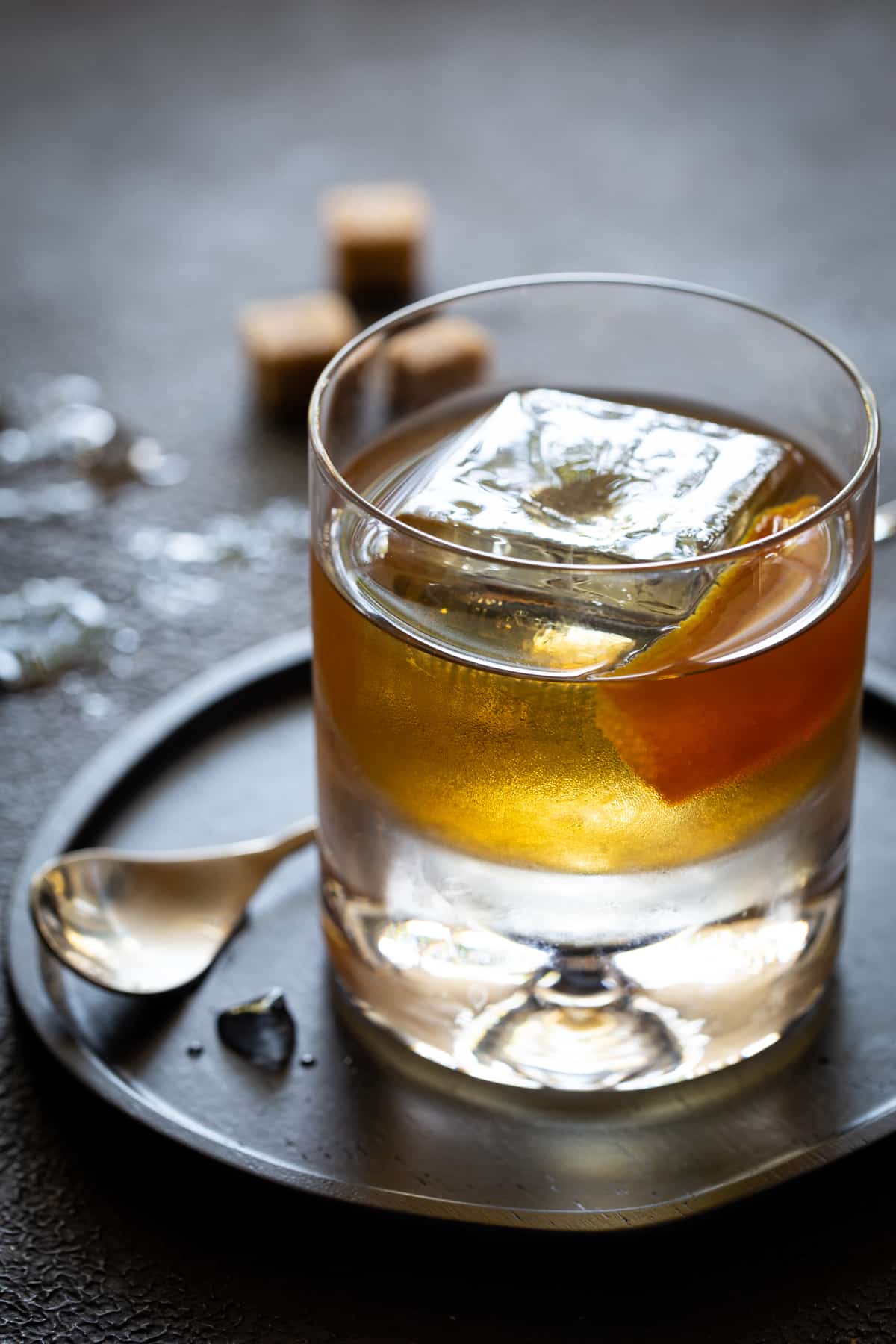 A glass cup on a table, with Old fashioned and Orange