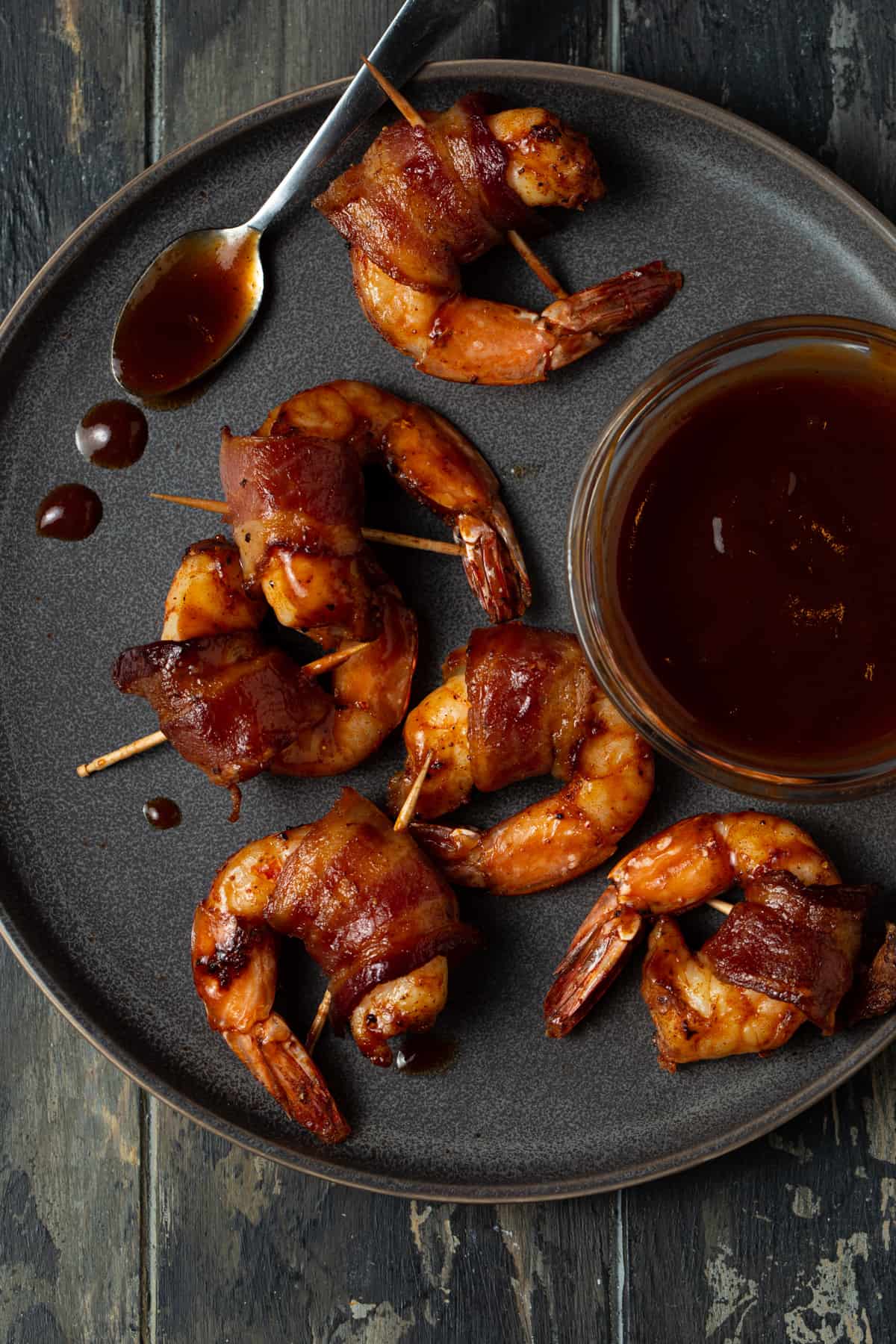 gray plate filled with shrimp and a small bowl of bbq sauce on the side.