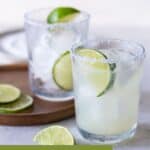 filled glasses garnished with limes and salted rims.