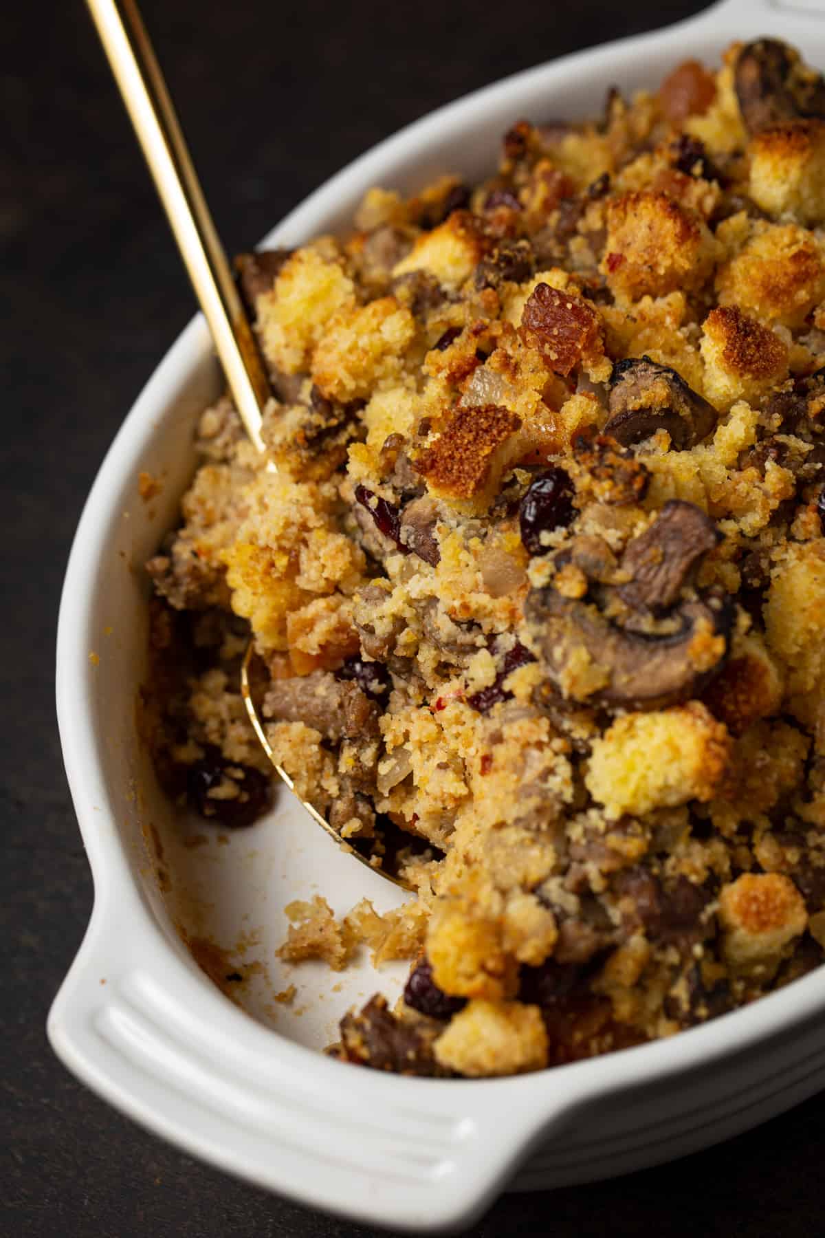 White oval casserole dish with cornbread sausage stuffing.