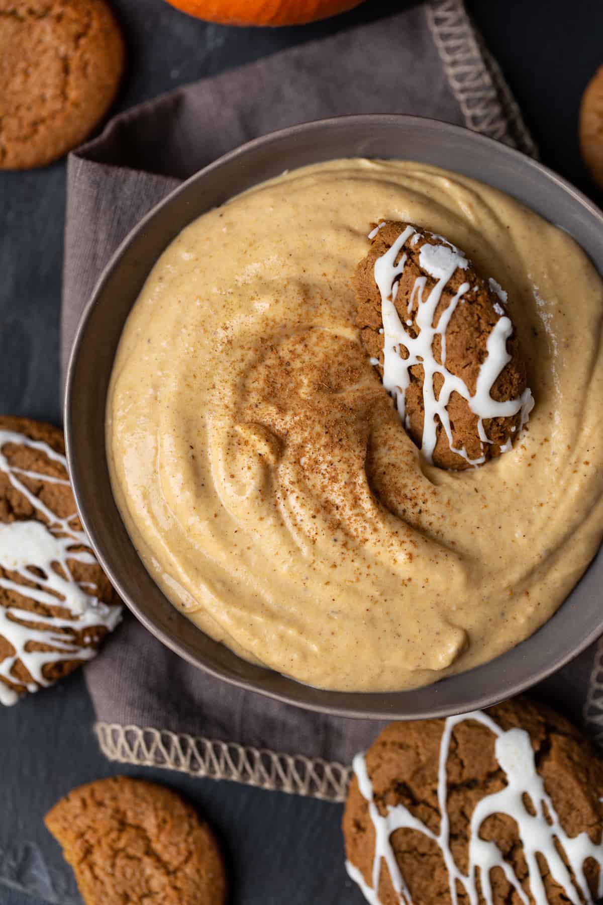 close up shot of dip in a gray bowl with gingersnaps and molasses cookies. 