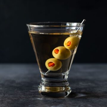 A glass of gin martini with olives.