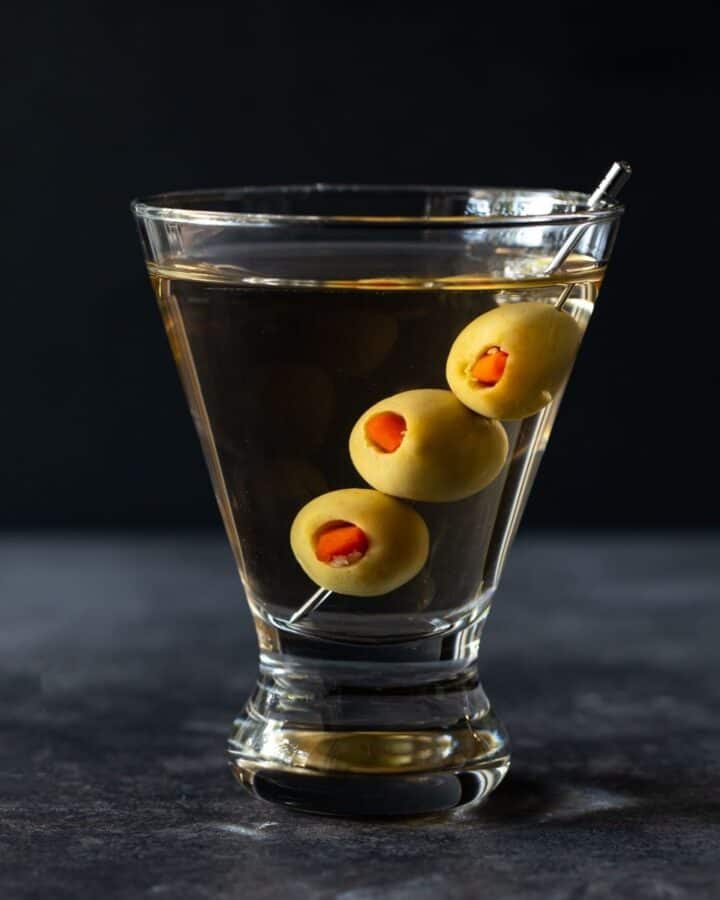 A glass of gin martini with olives.