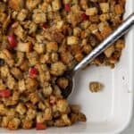 Stuffing in white pan with spoon.