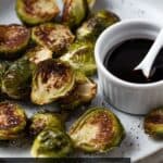 Roasted brussels sprouts with balsamic glaze in bowl.