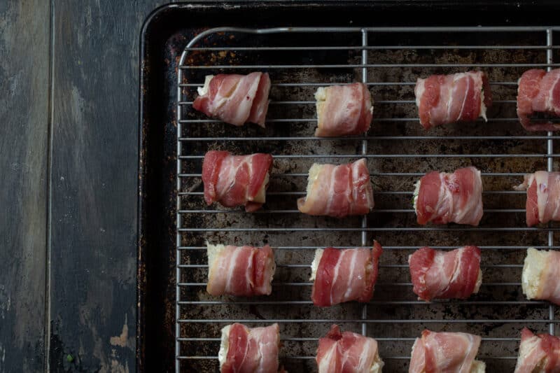 bacon rolls cut in half and on wire rack.