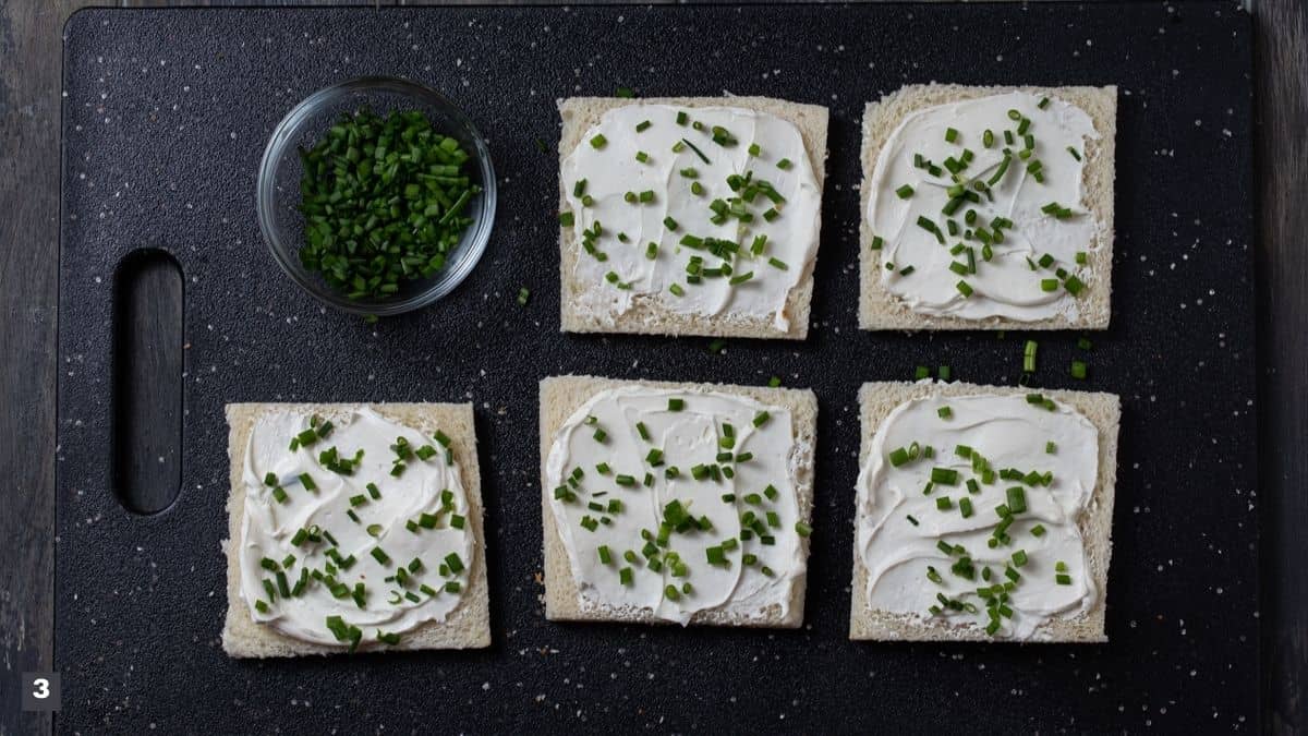 Slices of bread with cream cheese and chives on top.