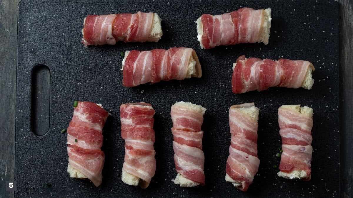 Pieces of bread rolled with bacon spiraled around.