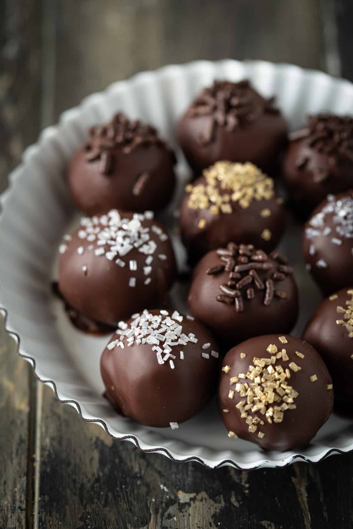 Decorated truffles in a small white metal fluted tart pan.