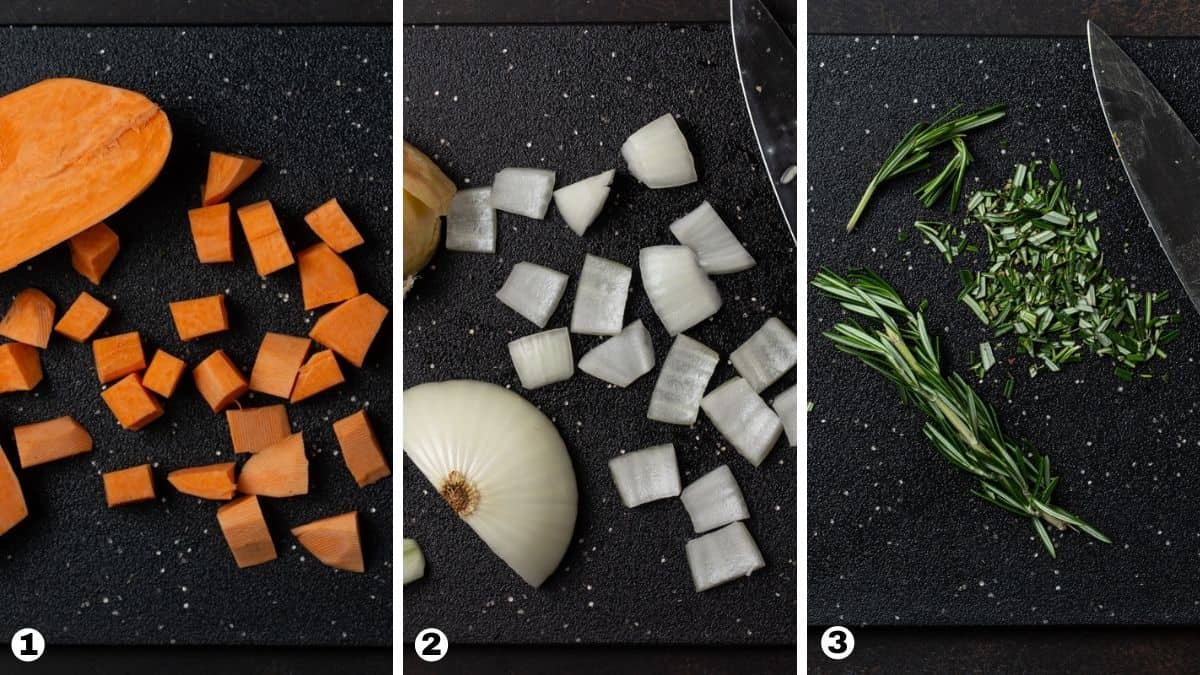 Chopped sweet potatoes, onions and rosemary on a black cutting board. 