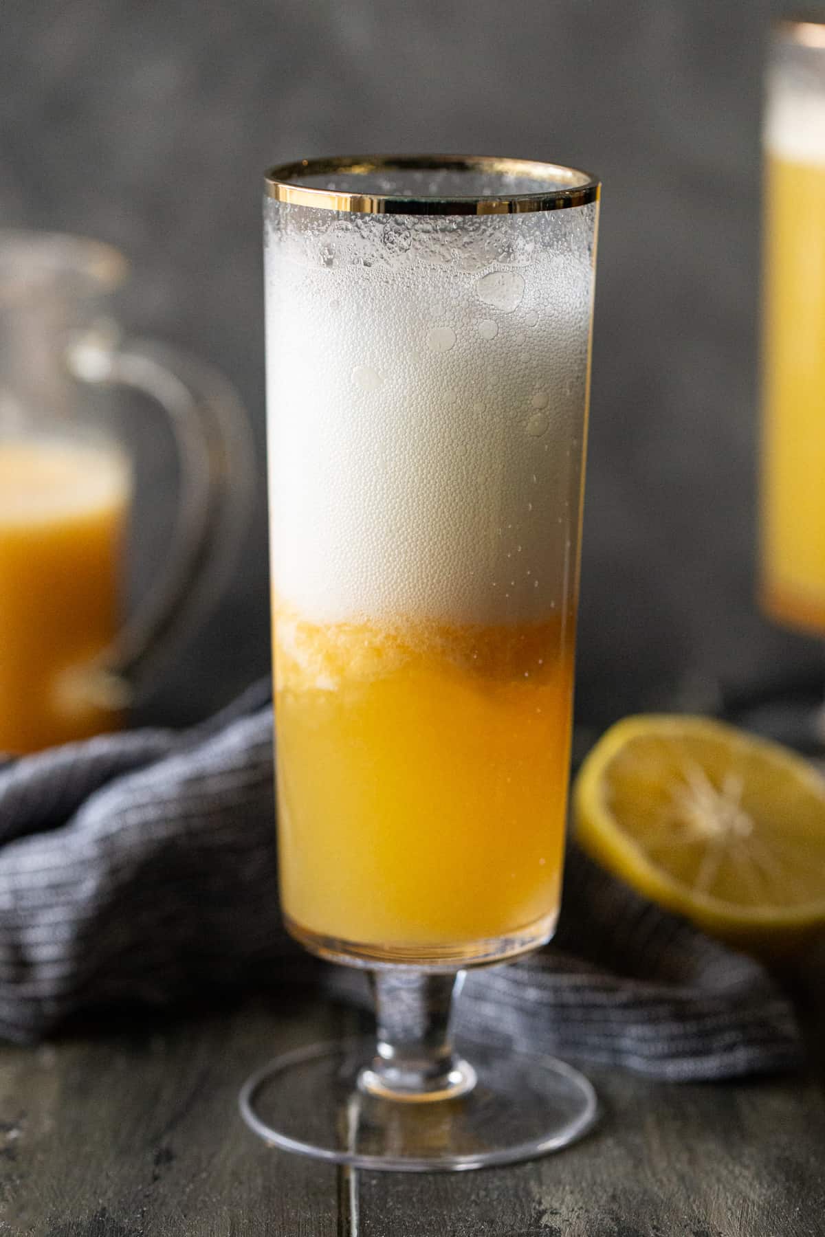 A glass of orange juice next to a pitcher, with Bellini and Non-alcoholic drink.