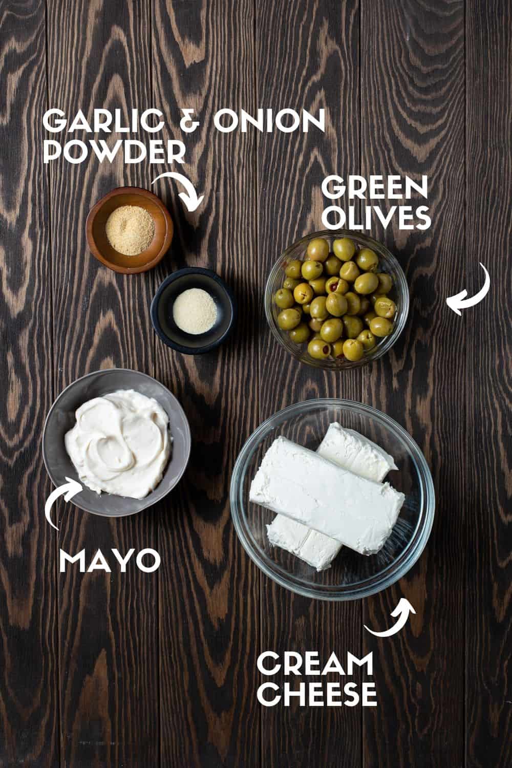 ingredients needed for olive dip on brown board.