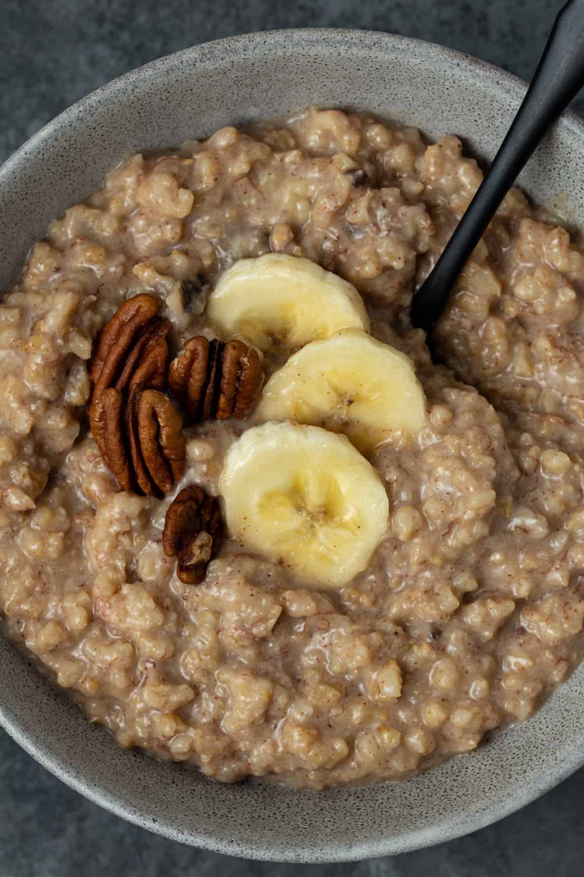 Gray bowl filled with Slow Cooker Steel Cut Oats with Bananas.