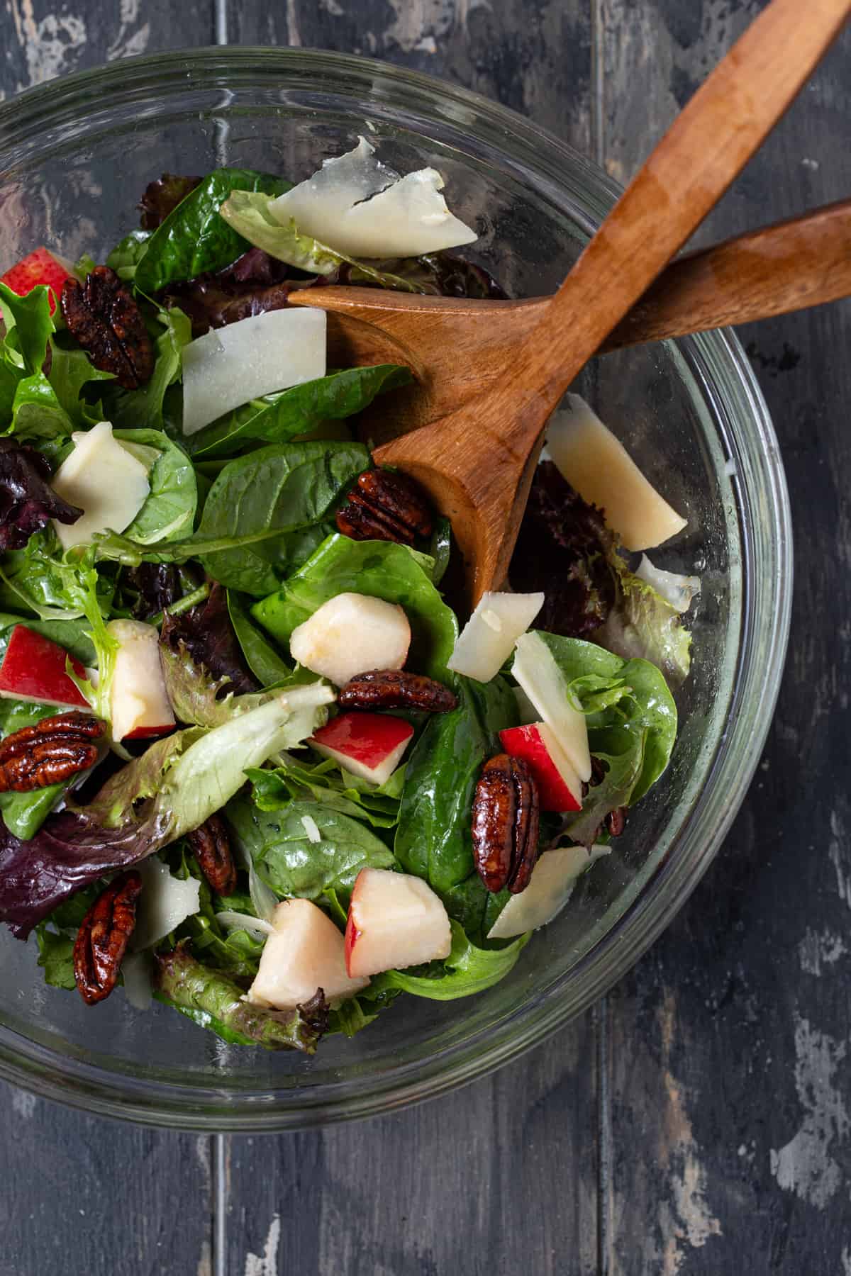 A bowl of salad, with Vinaigrette and Cheese.