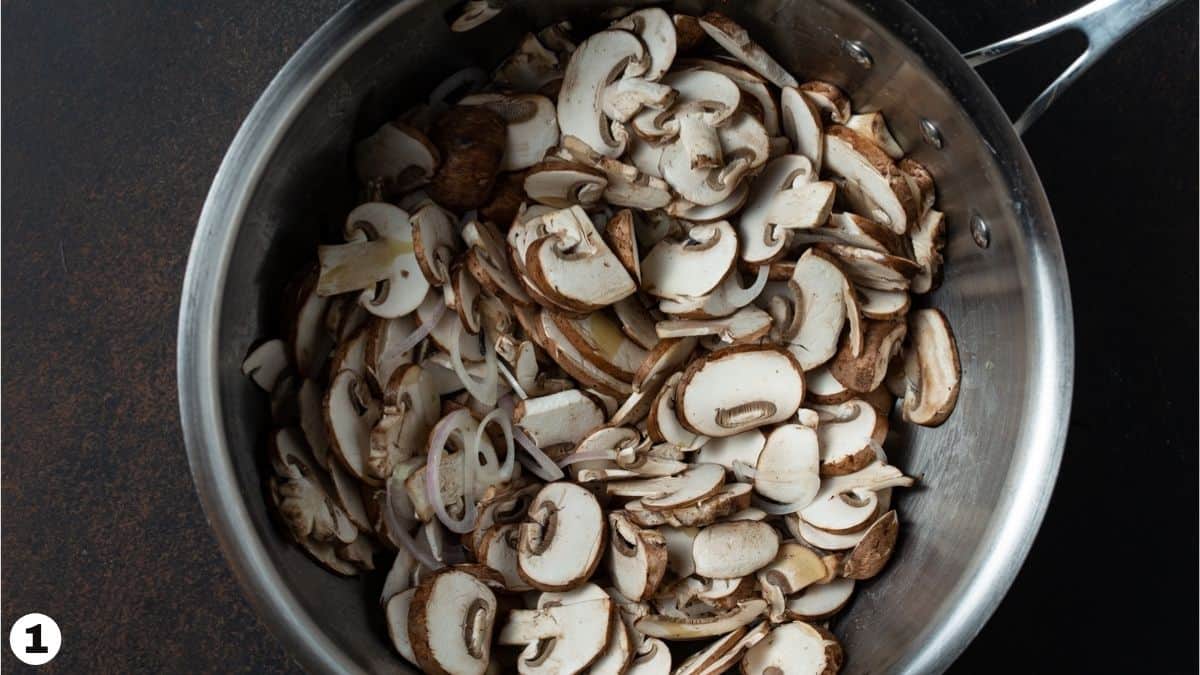 Sliced mushrooms and shallots in a pan. 