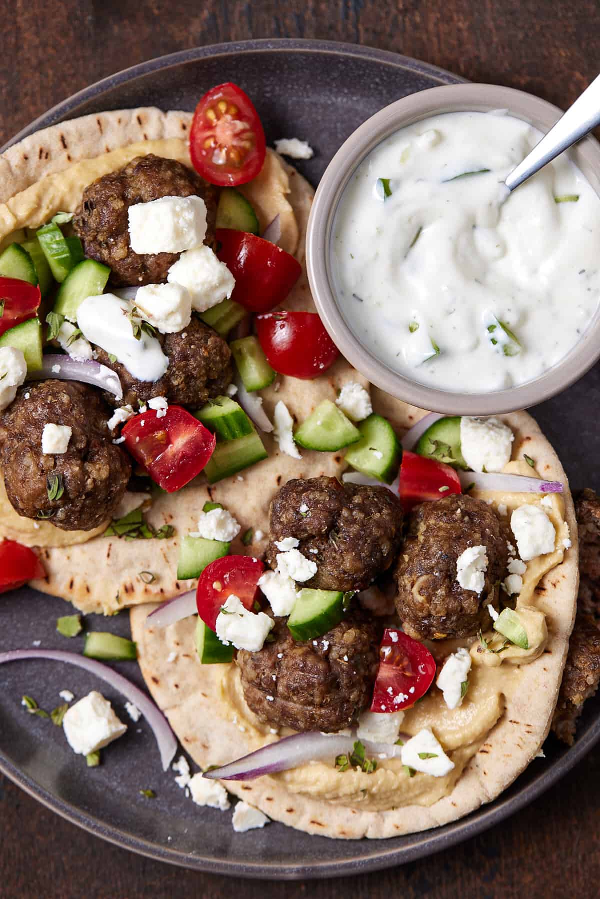 meatballs with pita on a plate with dipping sauce.