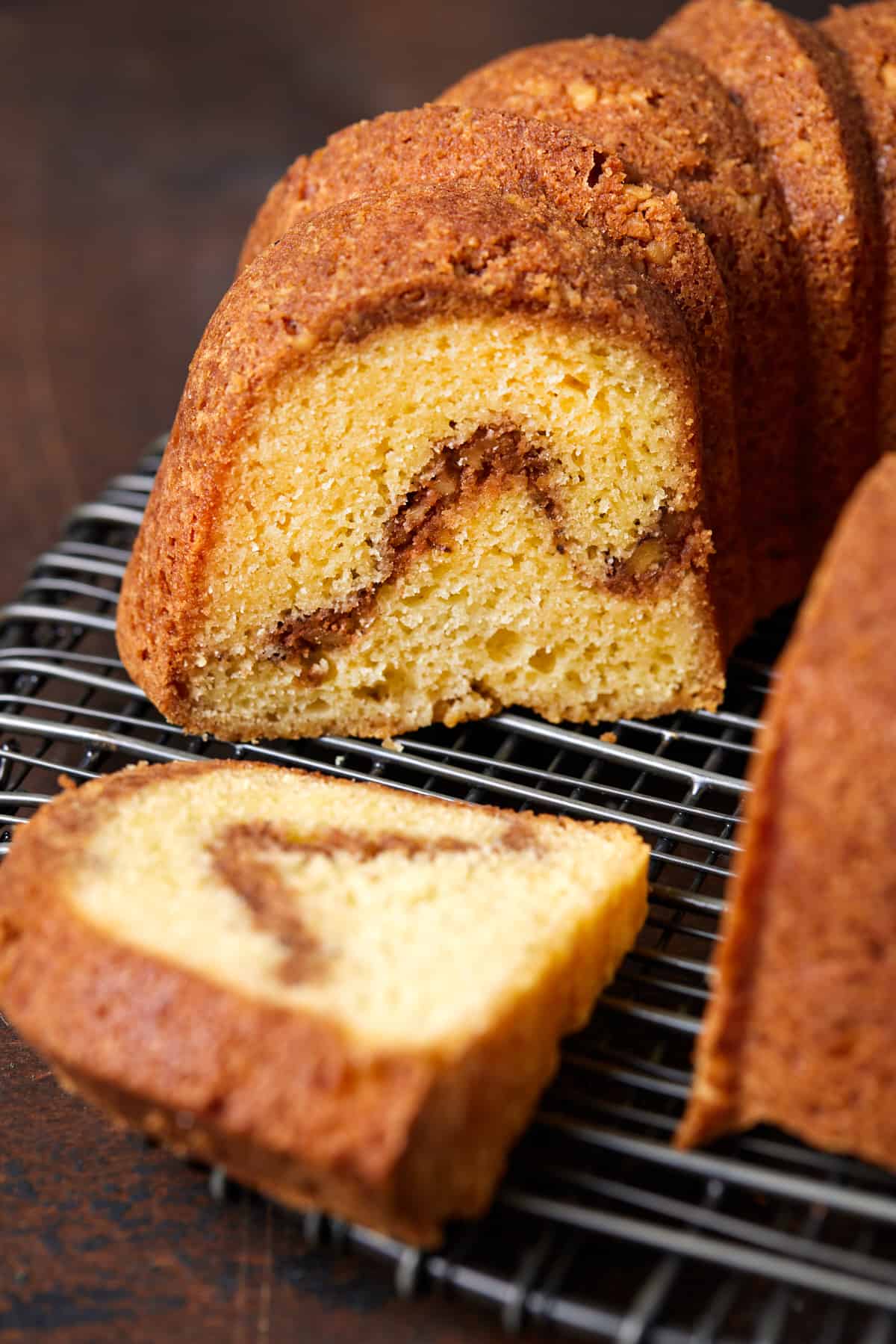 Sour Cream Coffee Cake on a cooling rack with a piece cut out. 