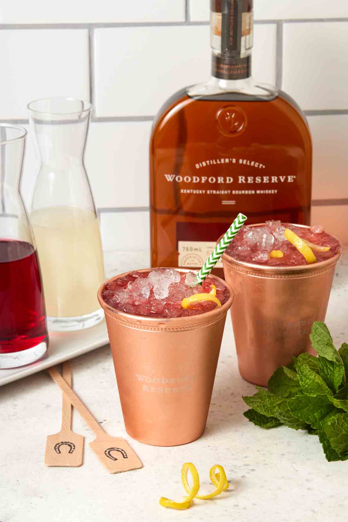 Two glasses of Woodford Spire Cocktails in ice-filled copper cups. 