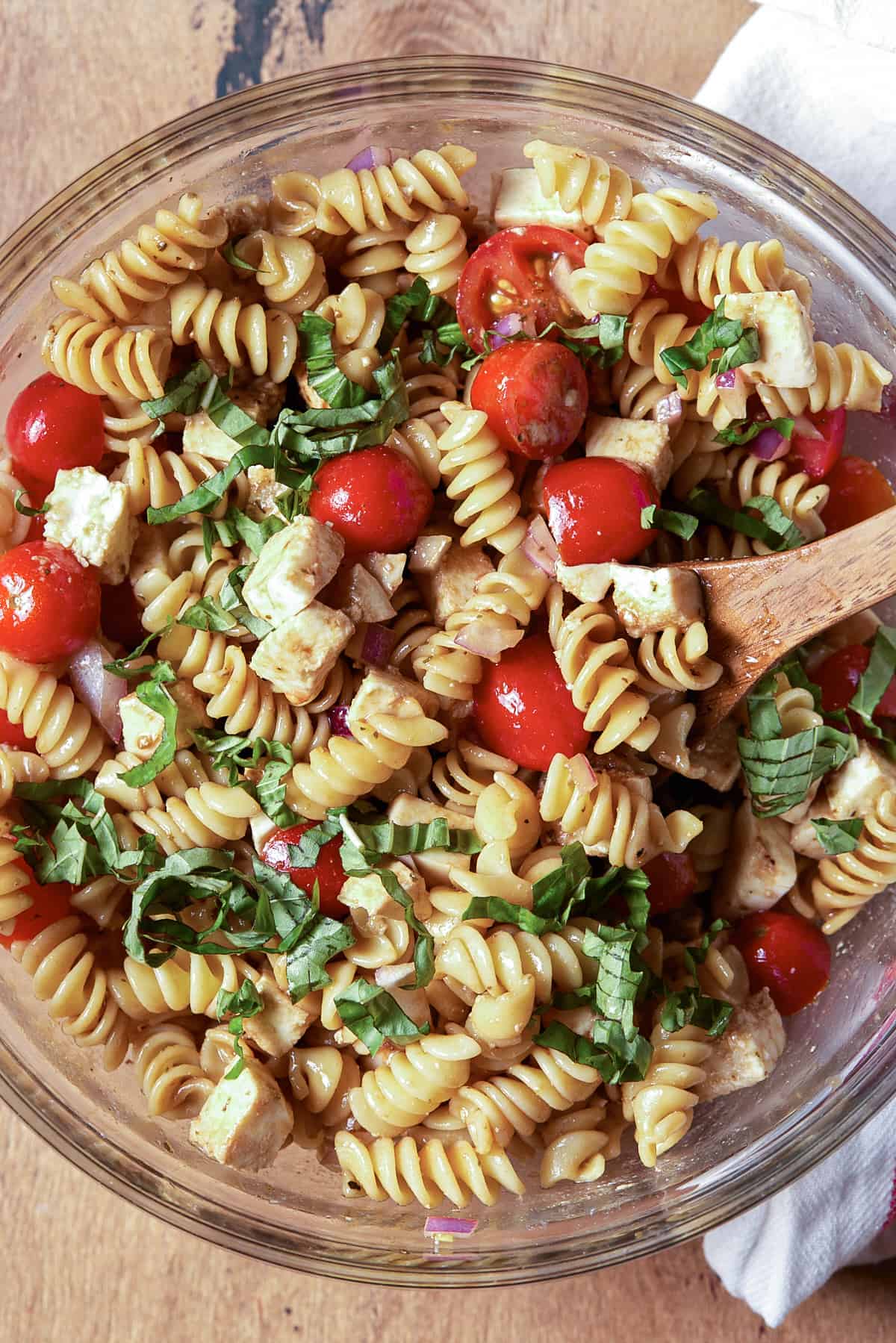 Caprese pasta salad in a glass bowl. 