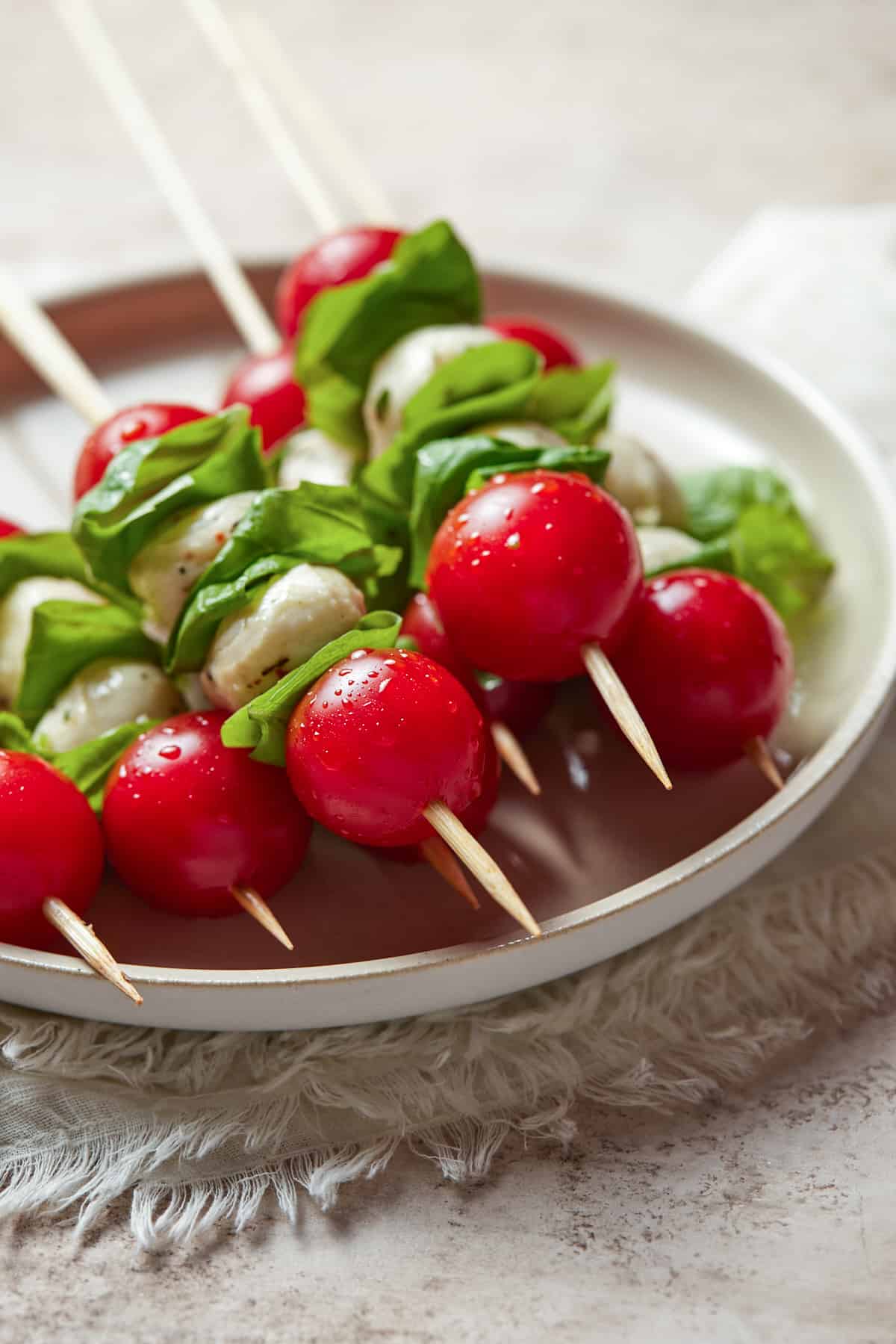 Caprese salad skewers on a white plate. 