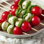 Caprese Skewers stacked on a gray plate.
