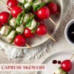 Caprese Skewers stacked on a plate drizzled with balsamic glaze.