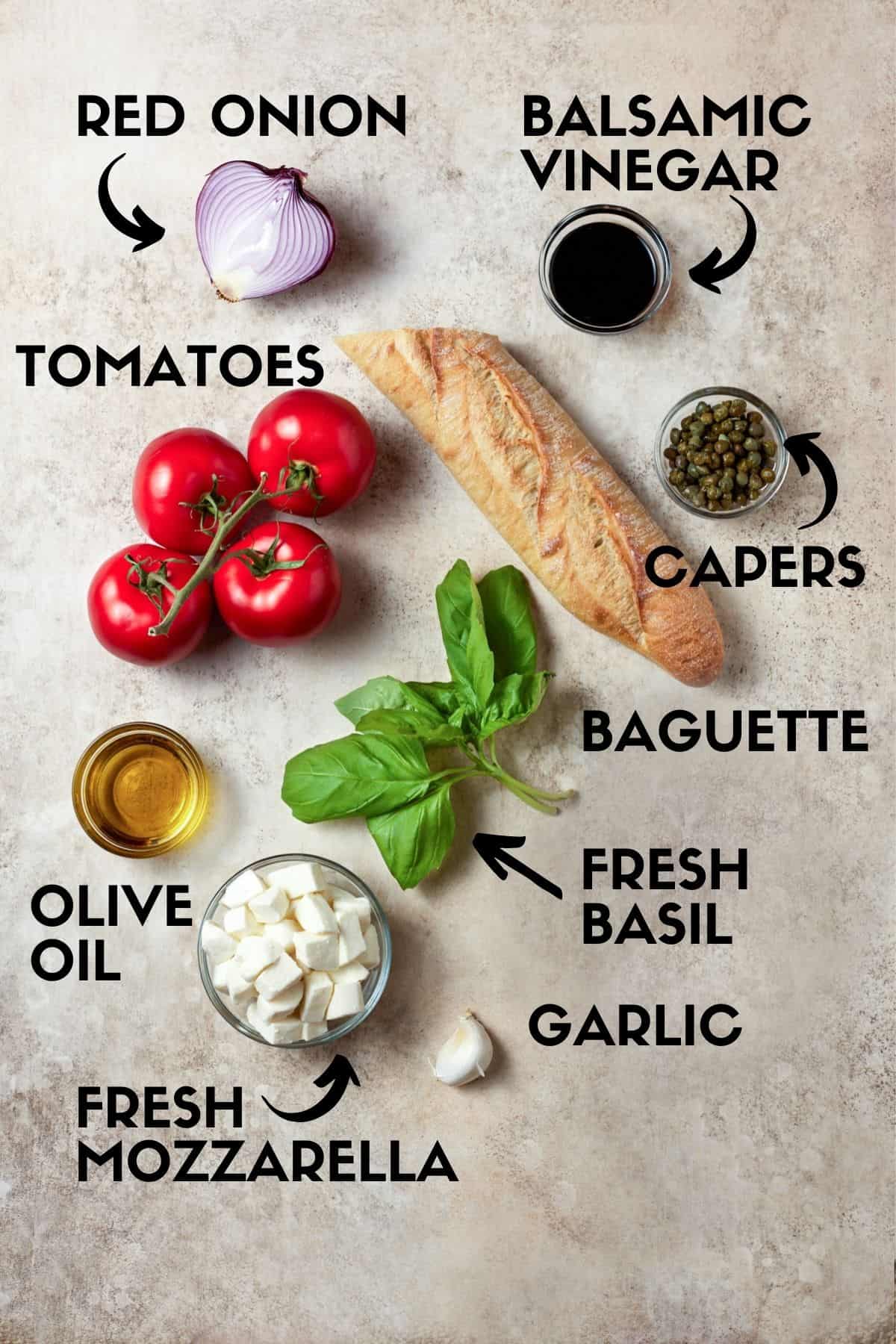 Panzanella salad ingredients including tomatoes, mozzarella cheese, bread and fresh basil. 