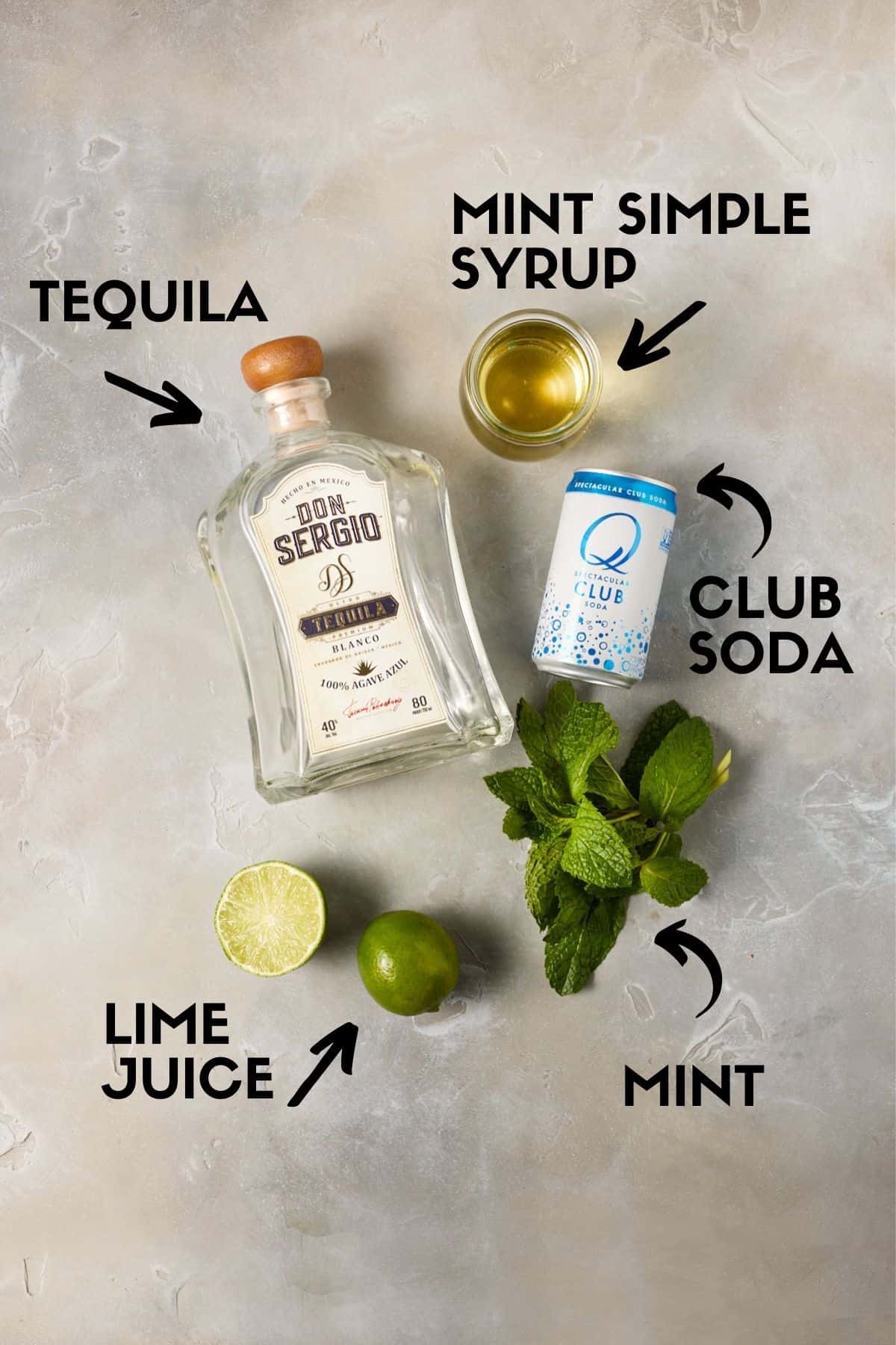 Ingredients for cocktail including tequila, club soda, lime juice and mint. 