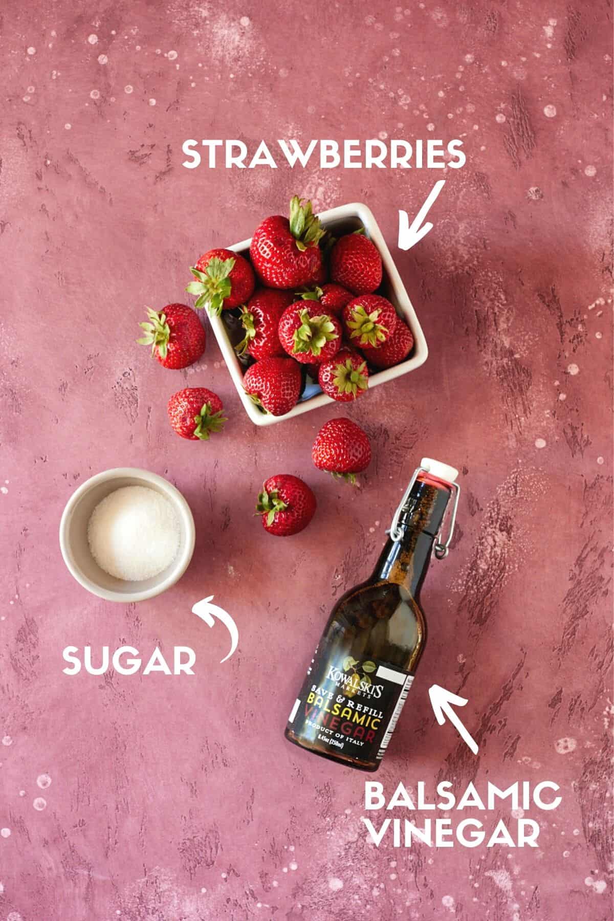 Strawberries, sugar and balsamic vinegar on a pink board. 