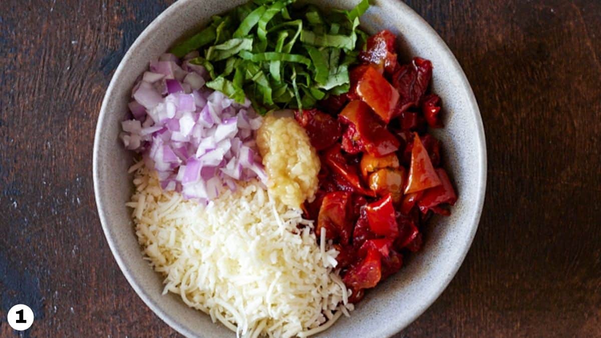 Tomato bruschetta ingredients in a grey bowl. 