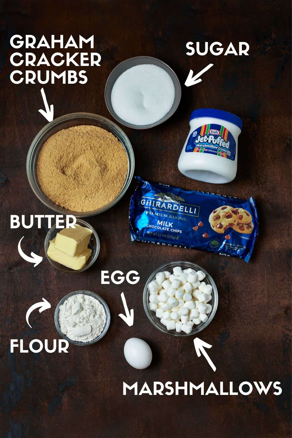 Ingredients for S'mores bars, including chocolate chips, graham cracker crumbs and marshmallow creme. 