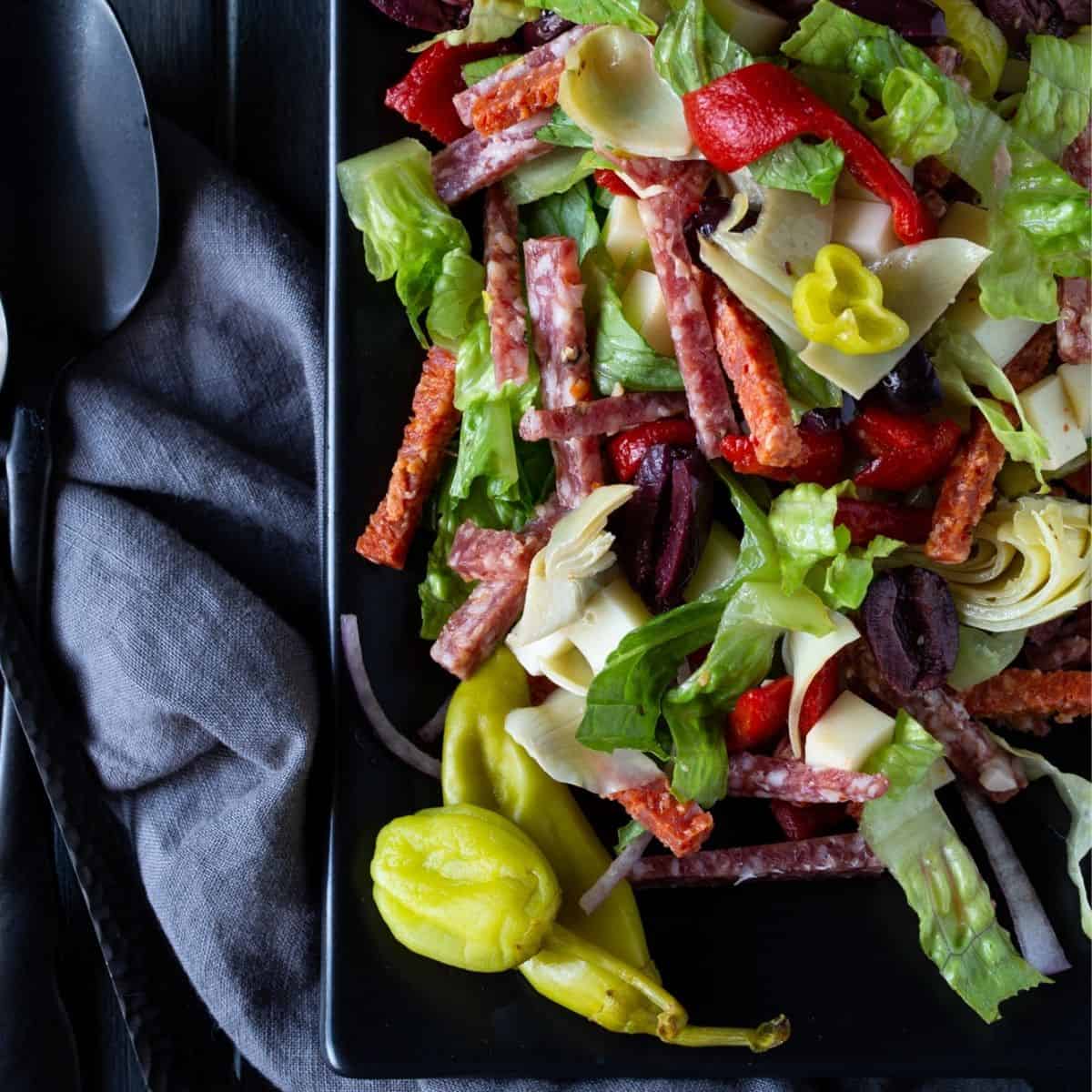 Black platter filled with antipasto salad.